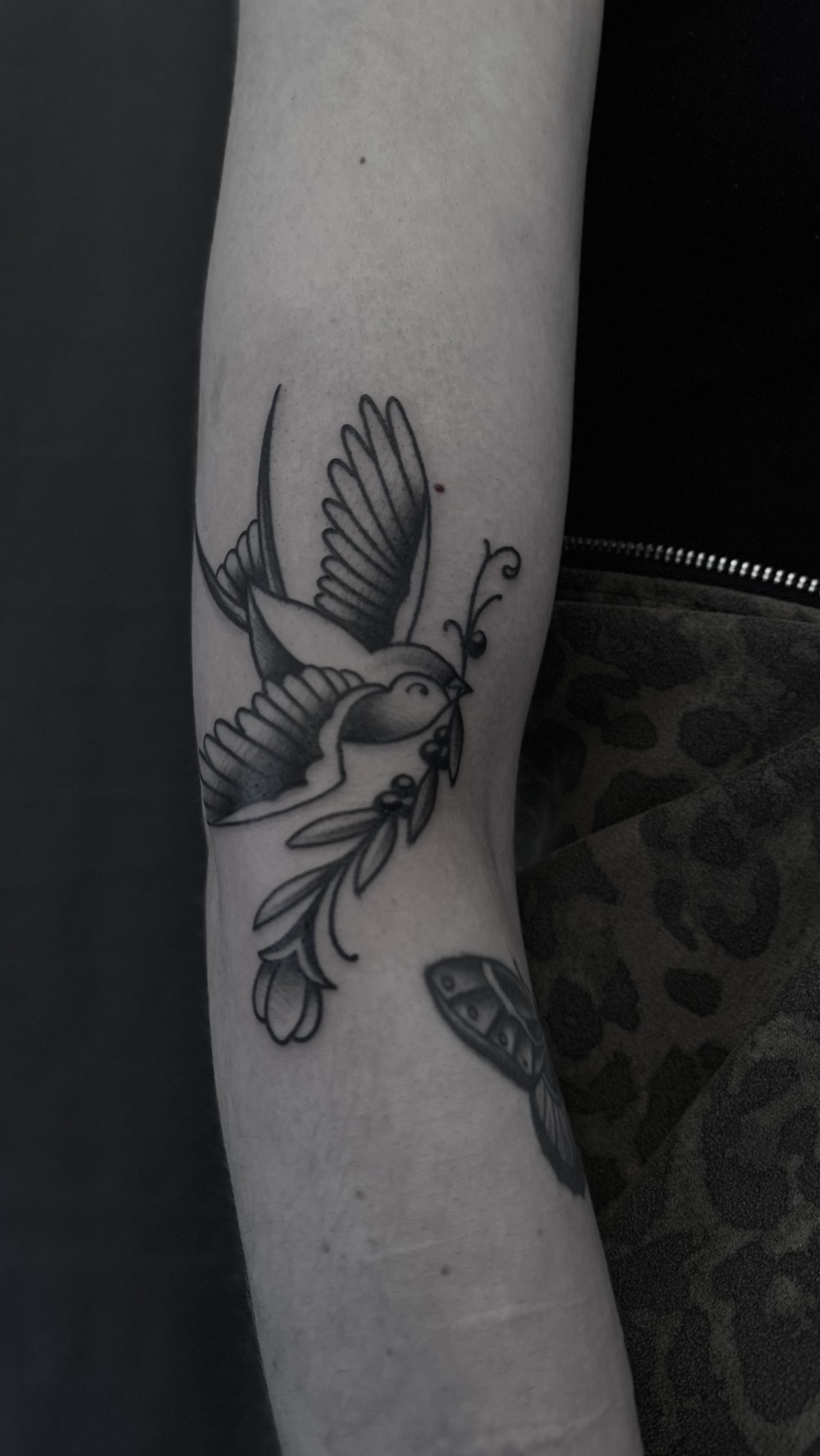 Schwalbe mit Blüte am Unterarm, Blackwork Tattoo von Andre bei Eine Liebe Tätowiergeschäft in Bochum