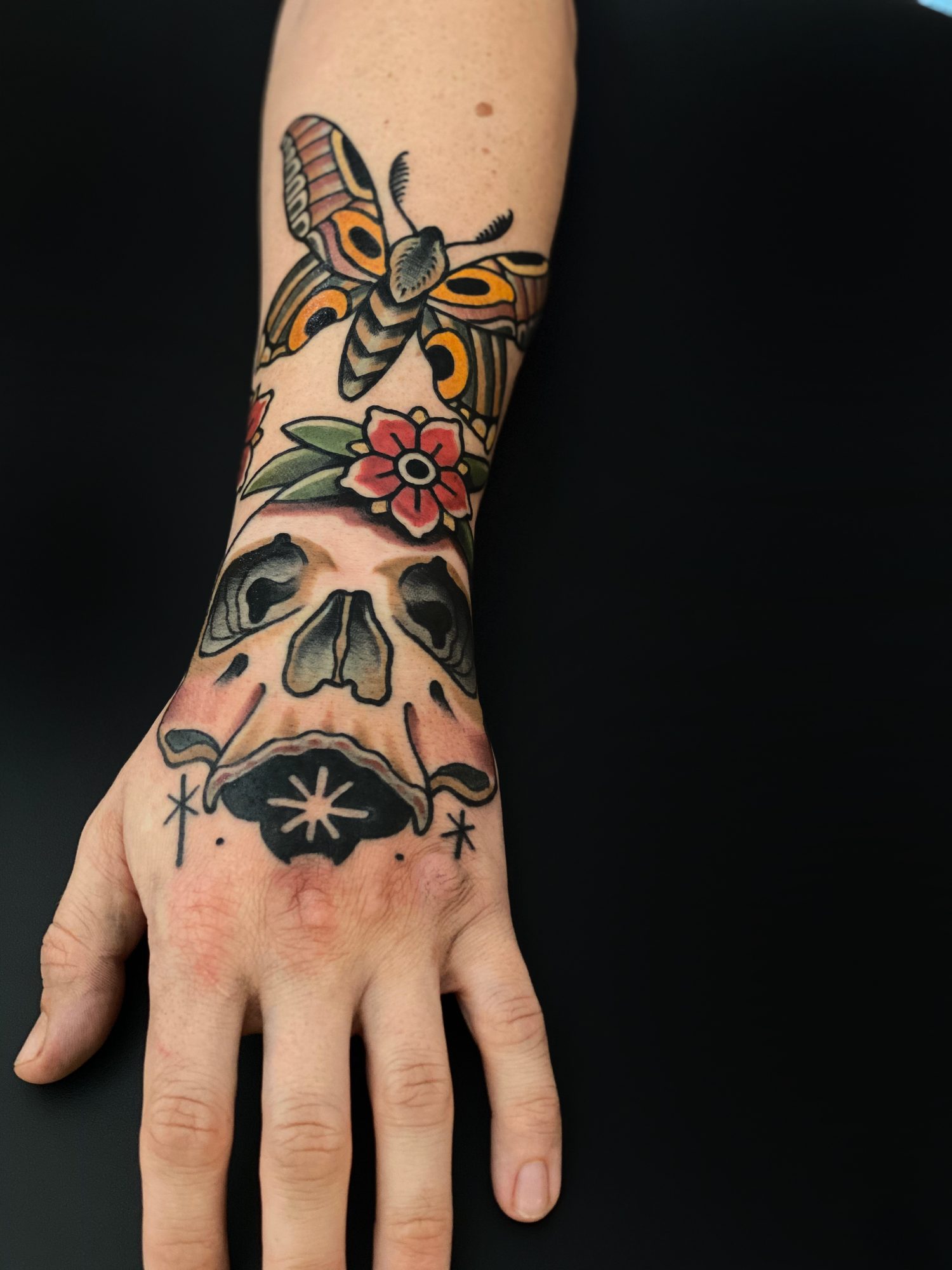 Motte, Blüte und Totenkopf auf der Hand, Hand Tattoo von Andre bei Eine Liebe Tätowiergeschäft in Bochum