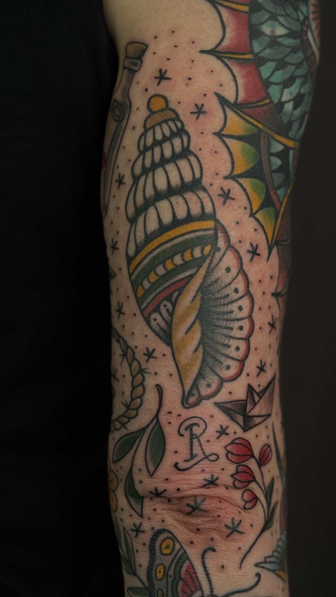 Schneckenmuschel mit Sternen am Unterarm, Traditional Tattoo von Andre bei Eine Liebe Tätowiergeschäft in Bochum