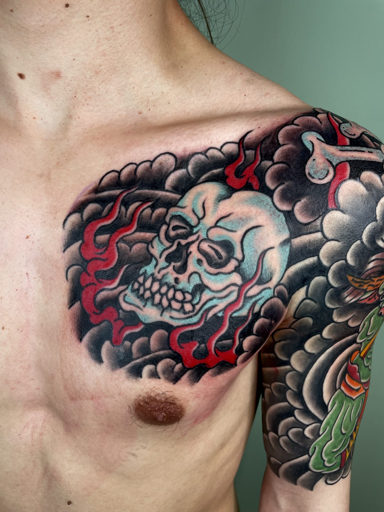 Totenkopf in Wolken und Flammen auf der Brust, Japanisches Tattoo von Jill bei Eine Liebe Tätowiergeschäft in Bochum