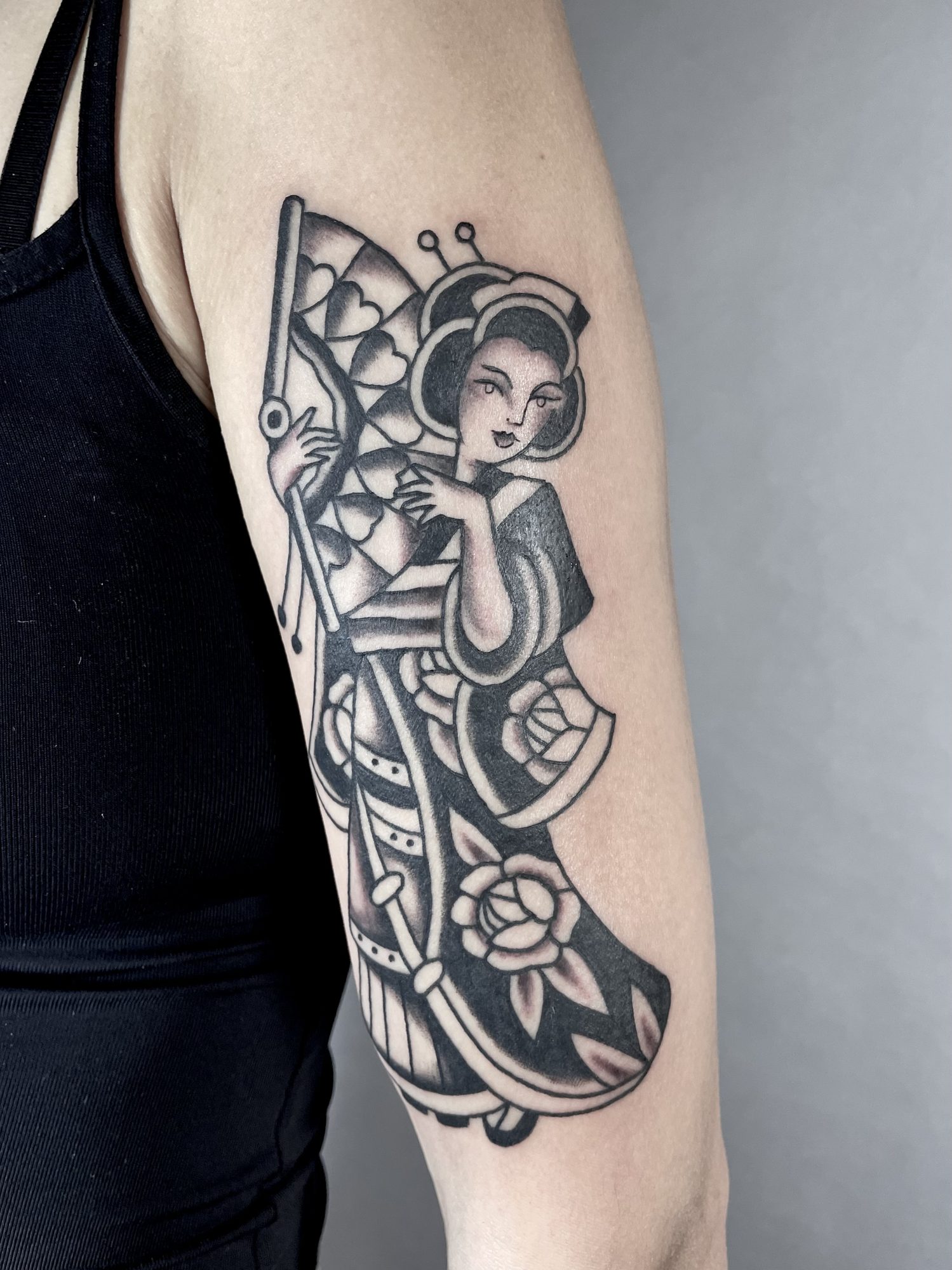 Geisha mit Fächer am Oberarm, Blackwork Tattoo von Jill bei Eine Liebe Tätowiergeschäft in Bochum