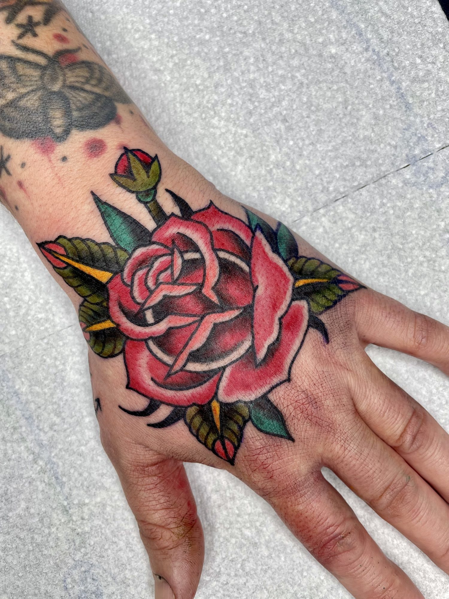 Rote Rose auf der Hand, Hand Tattoo von Jill bei Eine Liebe Tätowiergeschäft in Bochum