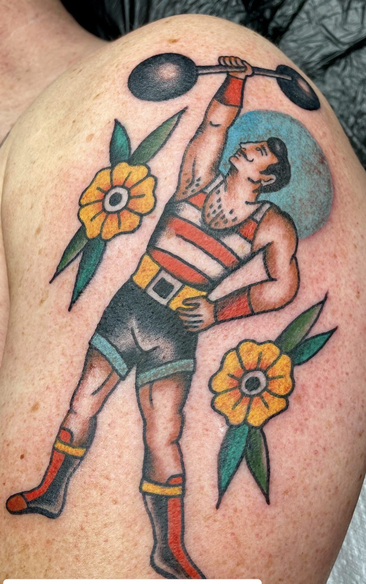 Kraftmensch mit Hantel am Oberarm, Pin-up Tattoo von Jill bei Eine Liebe Tätowiergeschäft in Bochum