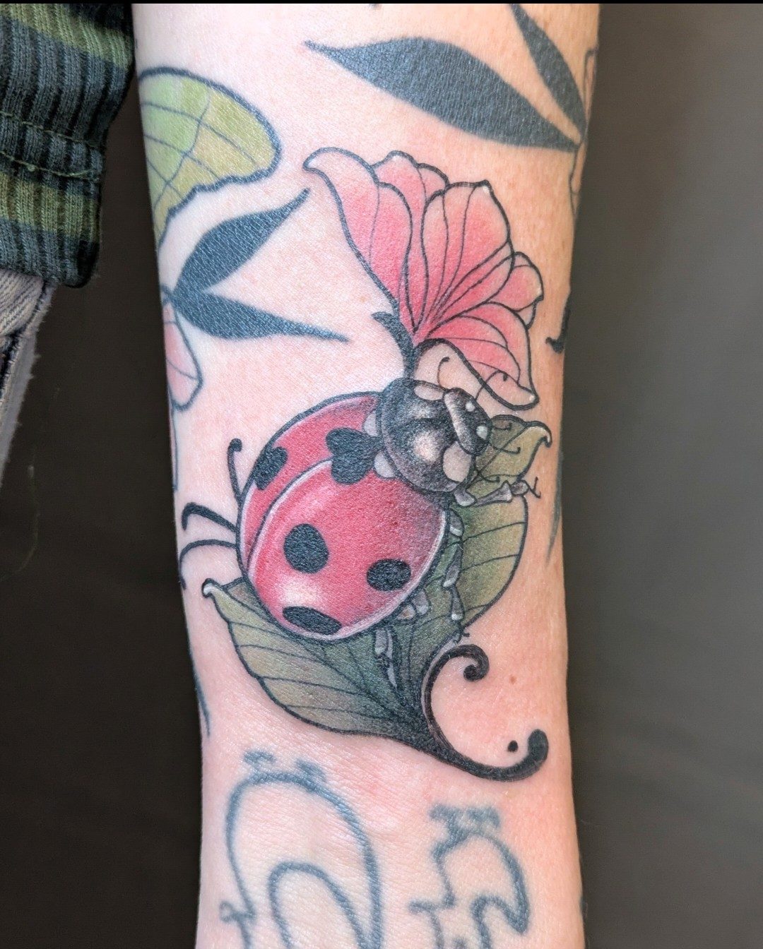 Marienkäfer mit Blüte am Unterarm, Blumen Tattoo von Melissa bei Eine Liebe Tätowiergeschäft in Bochum