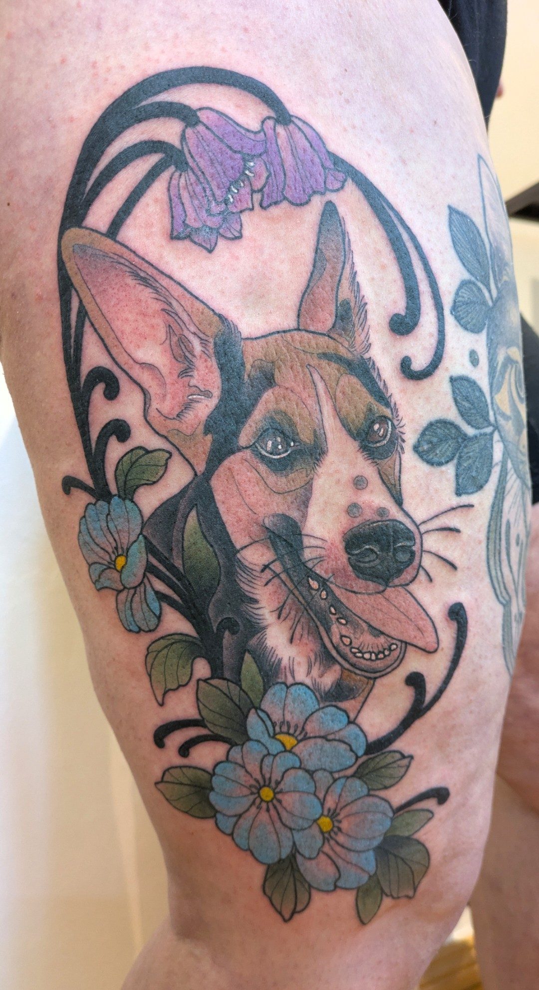 Hundeporträt mit Blüten am Oberarm, Neo Traditional Tattoo von Melissa bei Eine Liebe Tätowiergeschäft in Bochum