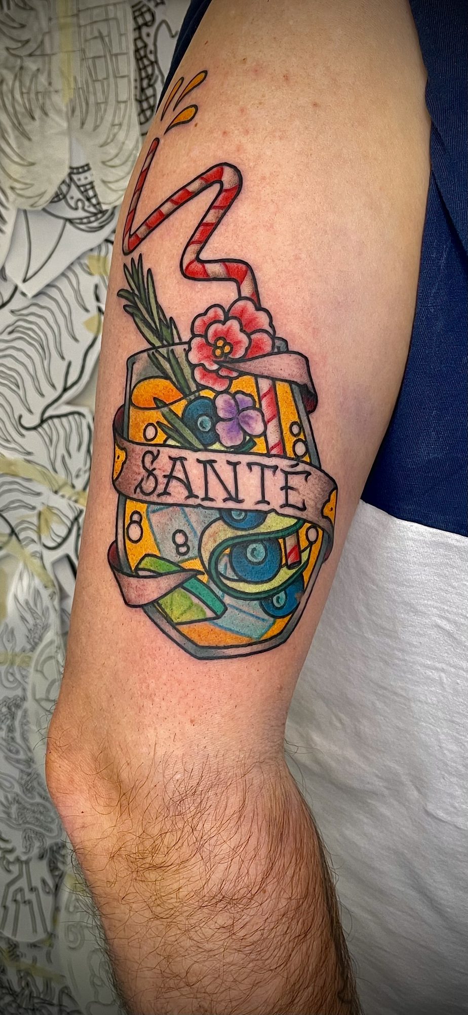 Cocktailglas mit Santé-Banner am Oberarm, Blumen Tattoo von Salle bei Eine Liebe Tätowiergeschäft in Bochum