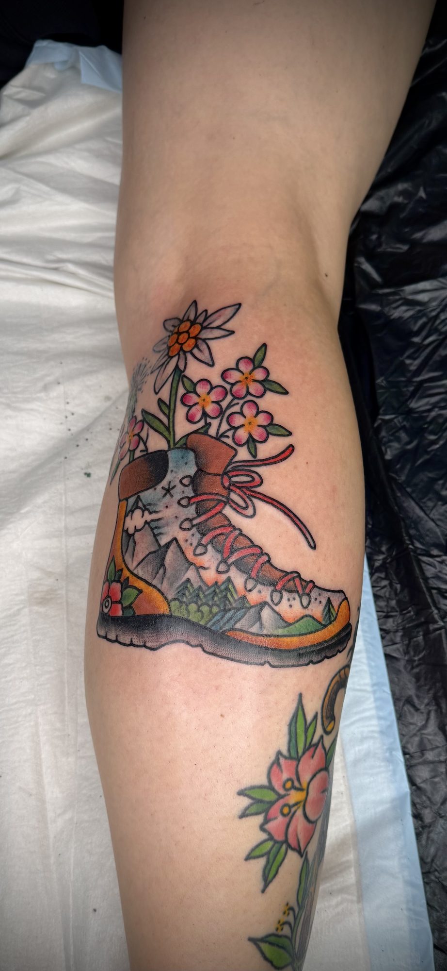 Wanderstiefel mit Blüten an der Wade, Blumen Tattoo von Salle bei Eine Liebe Tätowiergeschäft in Bochum