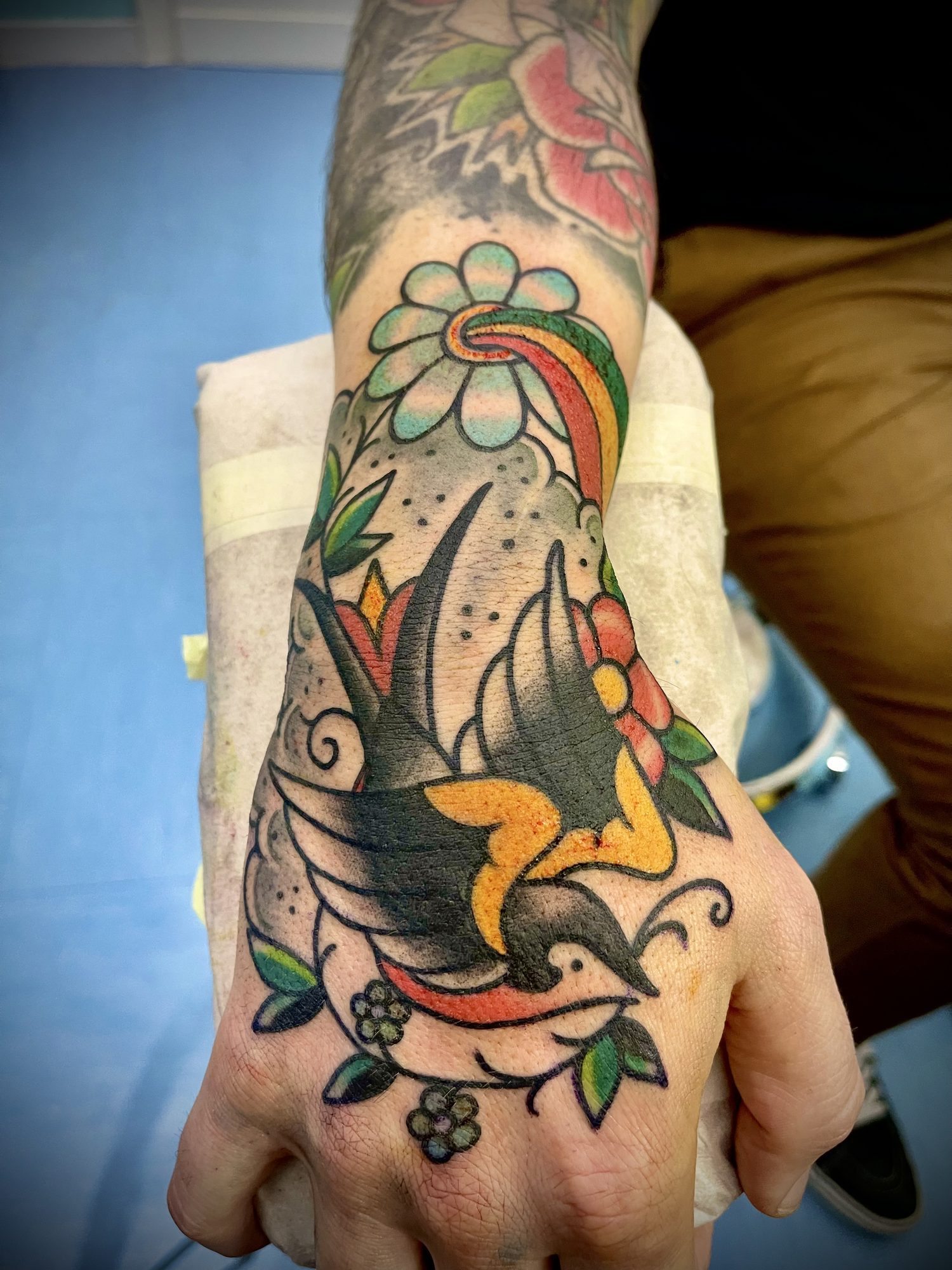 Schwalbe mit Regenbogen auf der Hand, Hand Tattoo von Salle bei Eine Liebe Tätowiergeschäft in Bochum