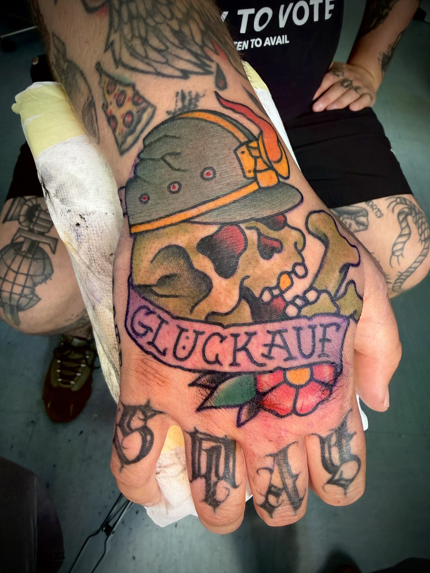 Totenkopf mit Grubenhelm und Glückauf-Banner auf der Hand, Hand Tattoo von Salle bei Eine Liebe Tätowiergeschäft in Bochum