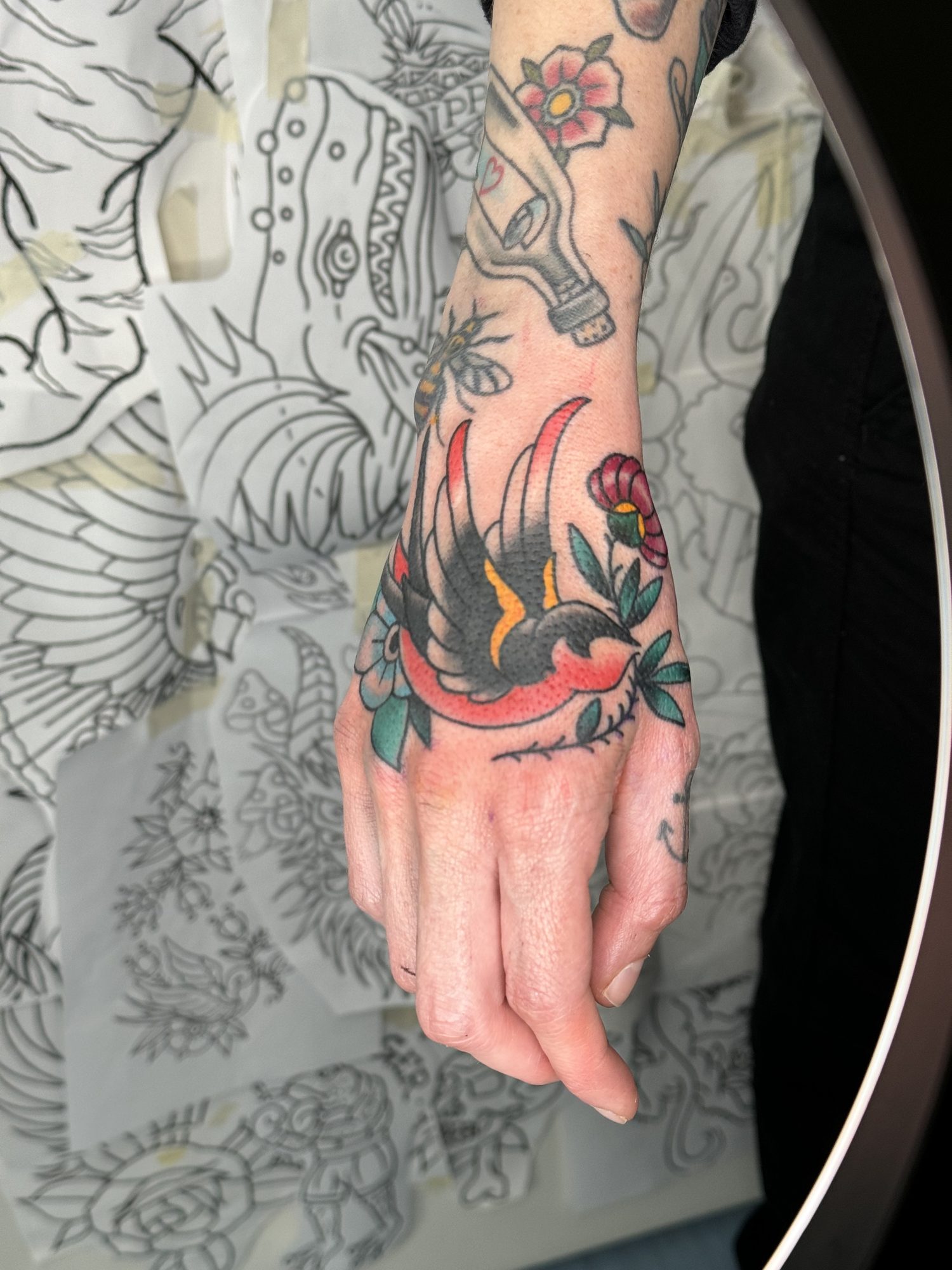 Schwalbe mit Blüte auf der Hand, Hand Tattoo von Salle bei Eine Liebe Tätowiergeschäft in Bochum