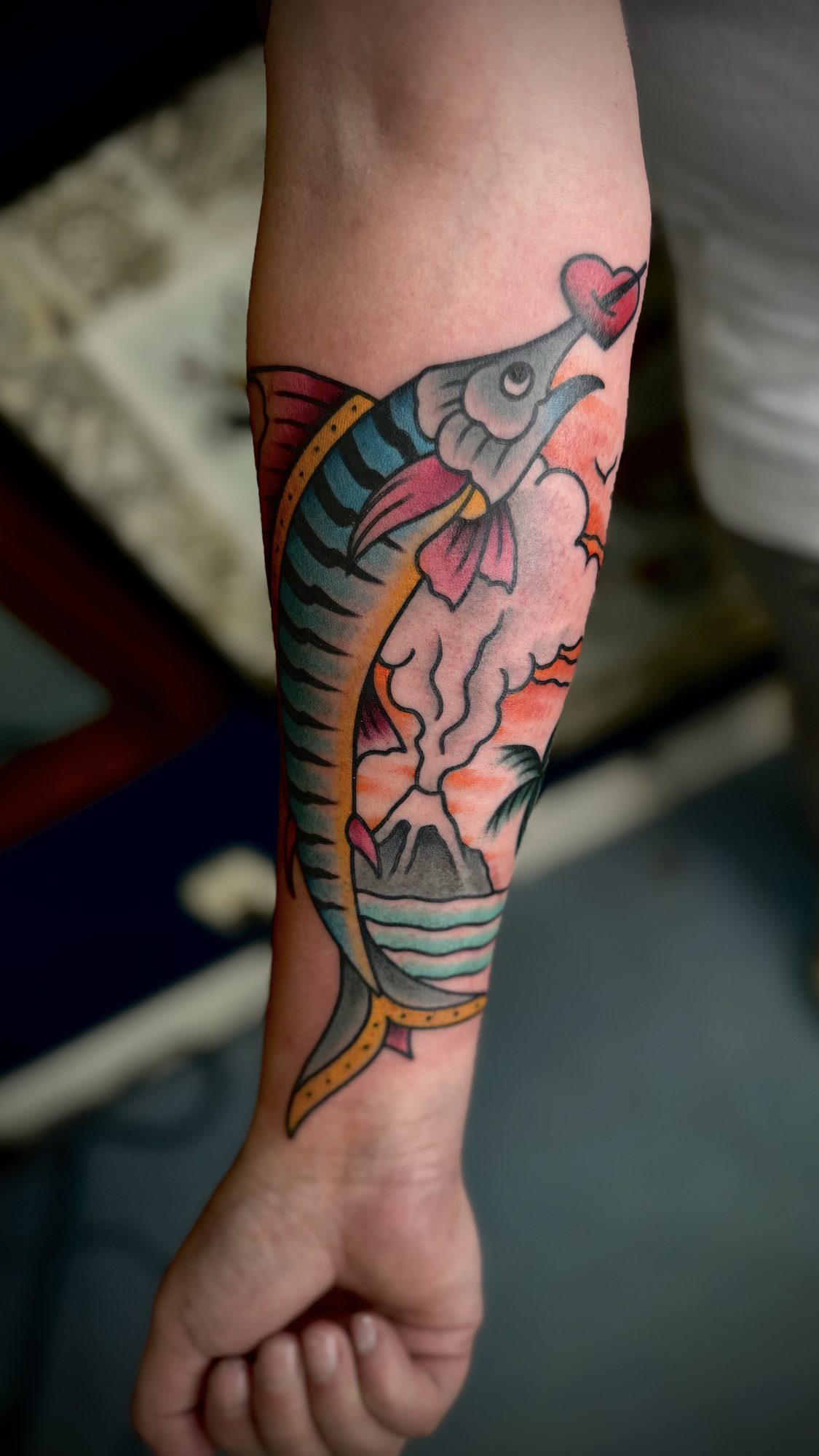 Fisch vor Vulkaninsel am Unterarm, Maritimes Tattoo von Salle bei Eine Liebe Tätowiergeschäft in Bochum