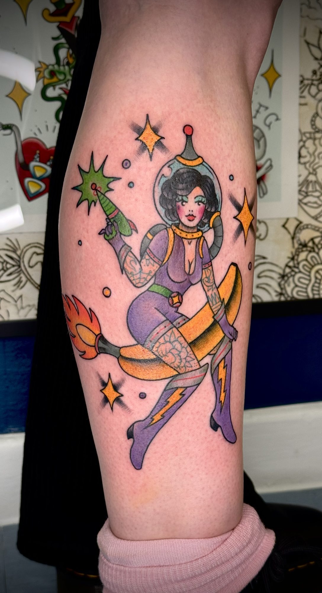 Space-Girl auf Banane an der Wade, Pin-up Tattoo von Salle bei Eine Liebe Tätowiergeschäft in Bochum